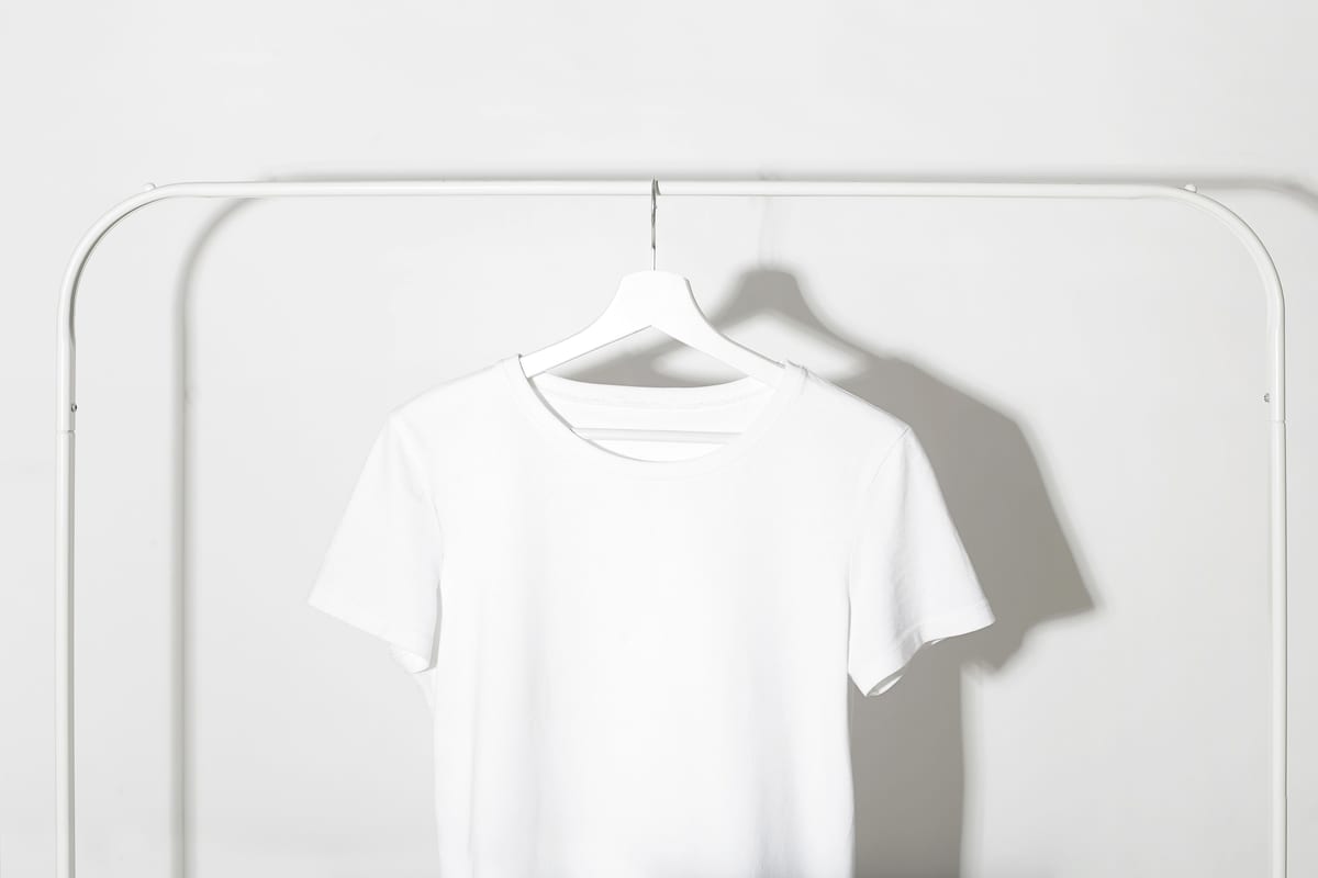 Plain white t-shirt on a hanger, the kind of blank a printed transfer is pressed onto
