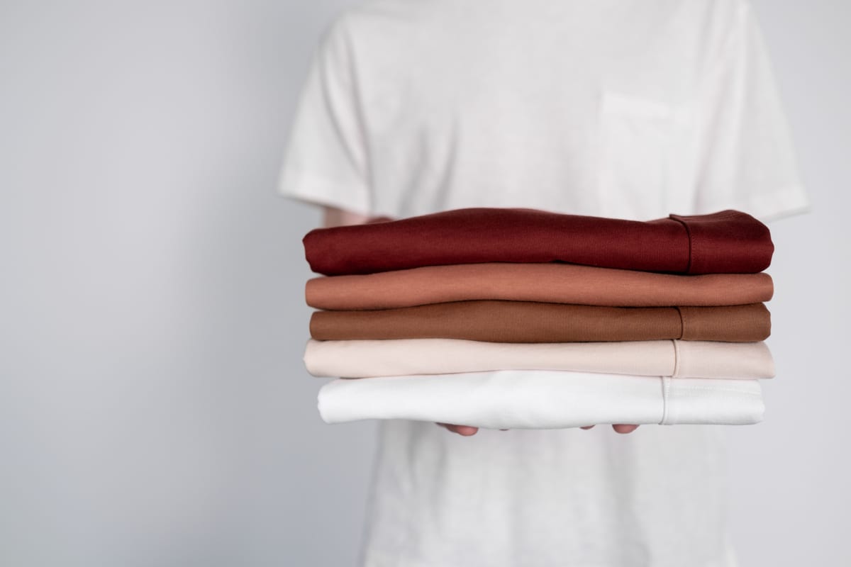 Stack of folded blank t-shirts in a range of colours, ready for branding