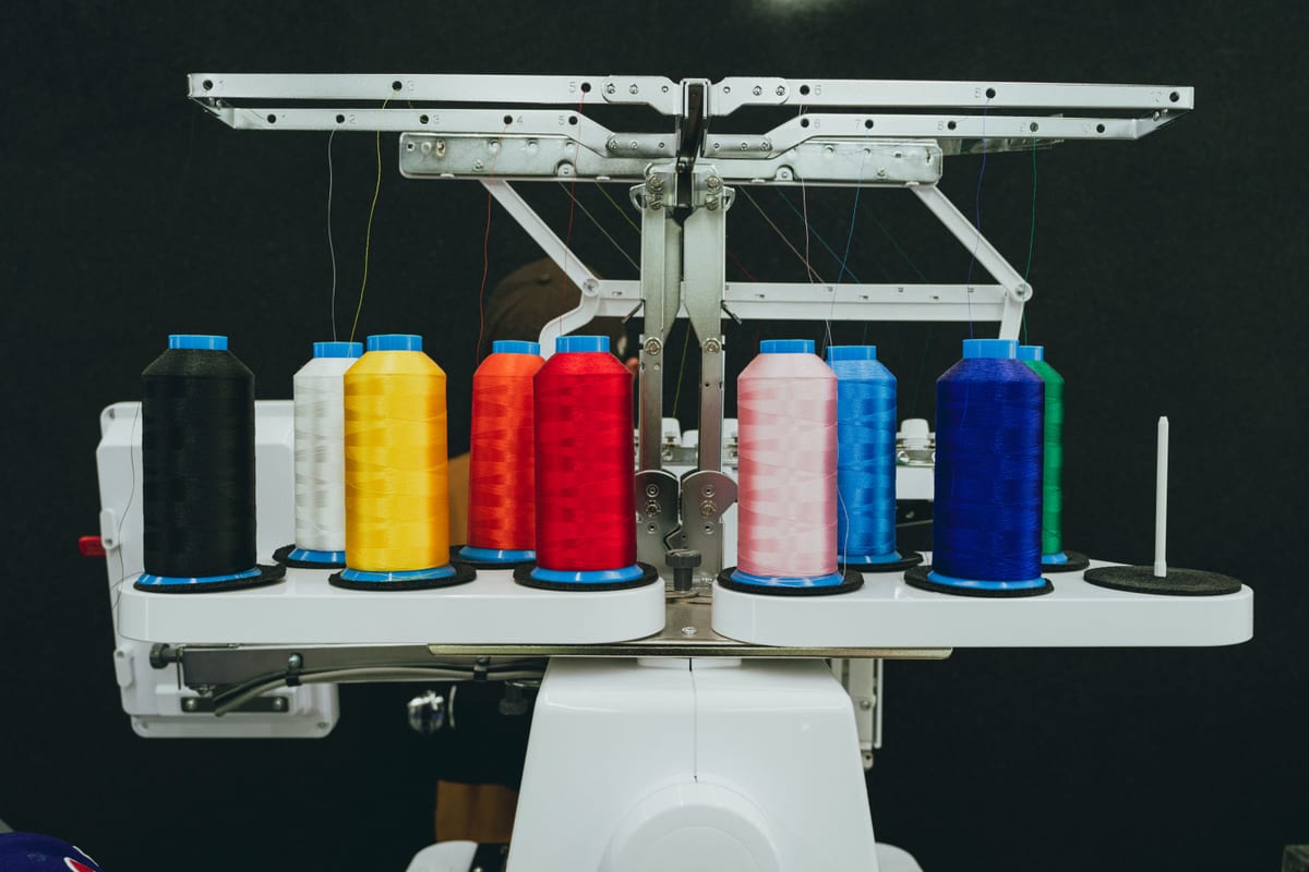 Thread spools feeding the head of an industrial embroidery machine