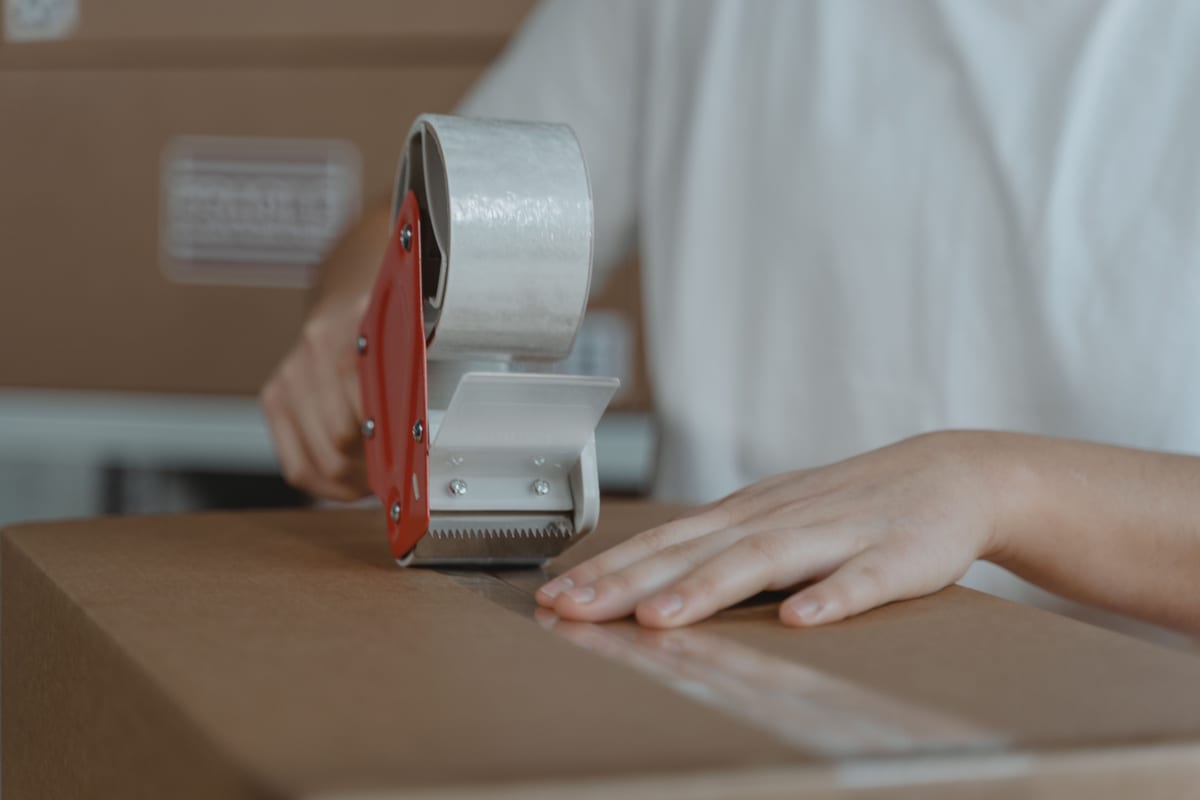 Sealing a carton of finished uniforms ready for courier dispatch